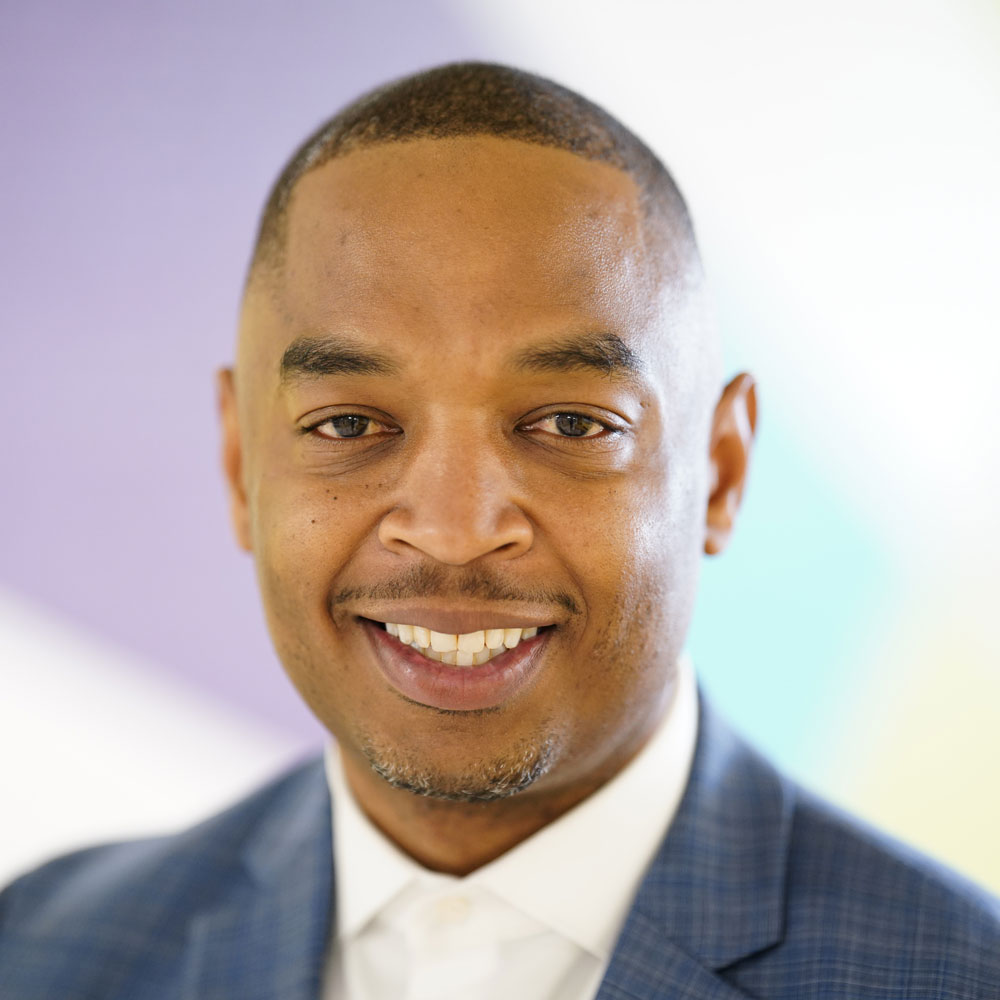 Torrence Rothmiller, Principal of Andrew Hamilton School Portrait of Torrence Rothmiller, principal of Andrew Hamilton School, smiling and wearing a blue suit jacket.